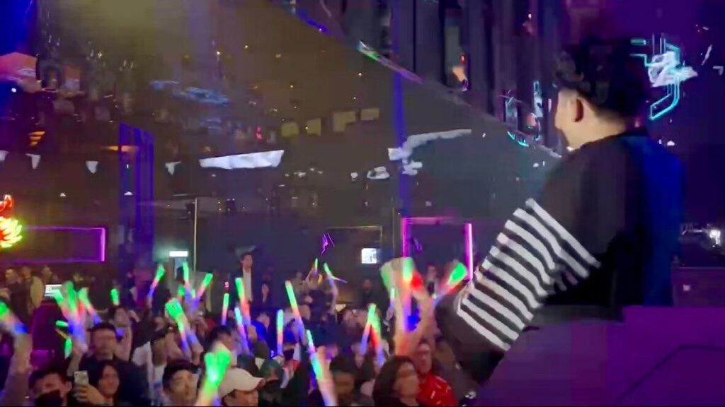 ペンライトで盛り上がる観客とDJ